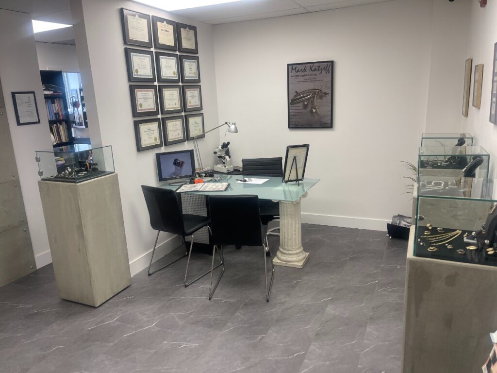 Jewelry consultation office with a private desk, chairs, and framed artwork