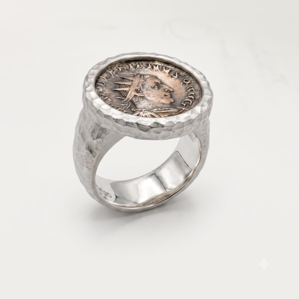 Silver ring featuring an engraved round centerpiece and ornate textured band”