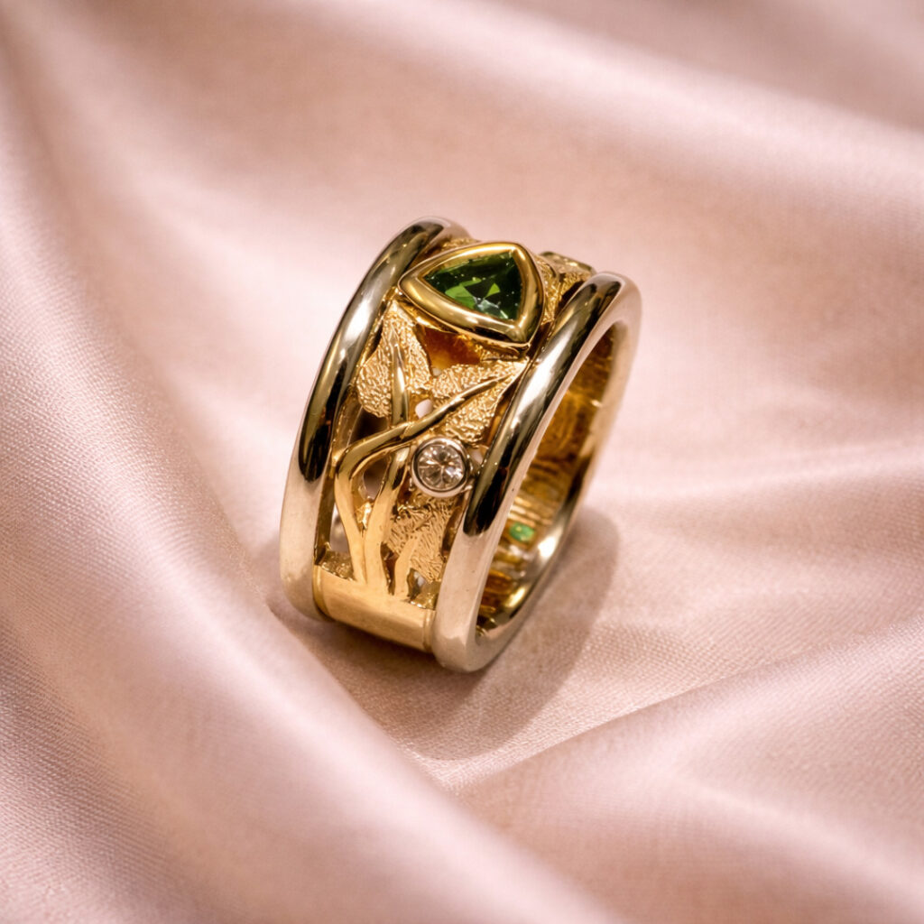 Gold gemstone ring with a triangular green stone, textured design, and diamond accent