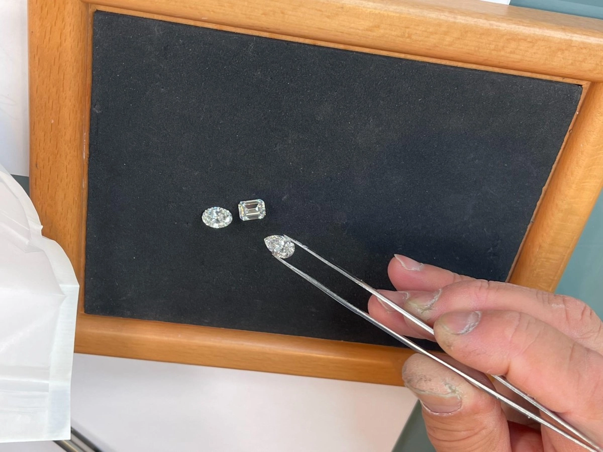 Jeweler doing gemstone sourcing with precision tweezers