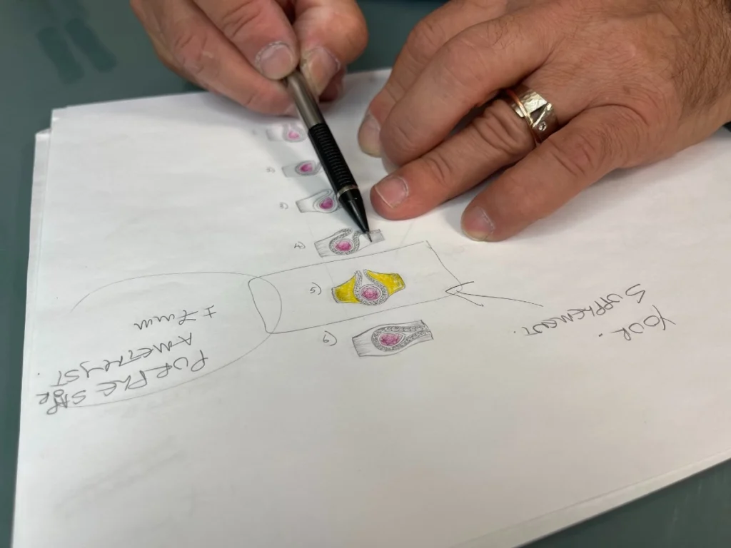 Jewelry designer sketching custom ring designs on paper